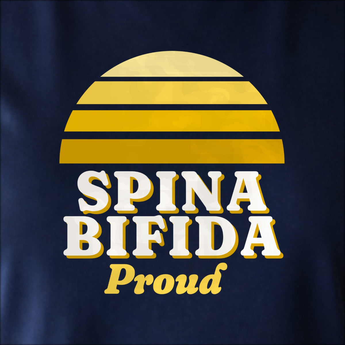 Close-up of the print on navy: a striped half-sun in yellow above cream SPINA BIFIDA lettering with “Proud” in script.