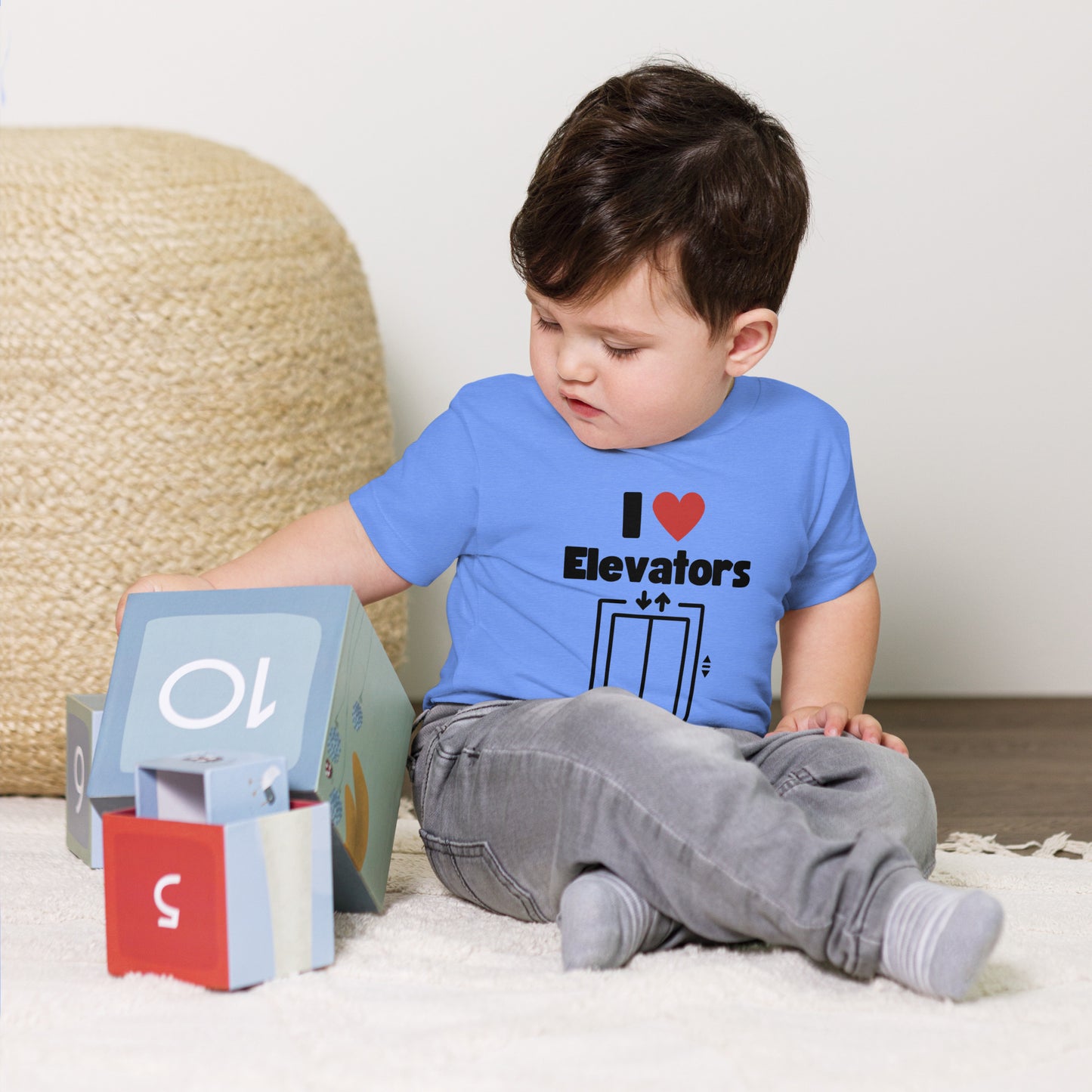 Child wearing a t-shirt with 'I ❤️ Elevators' design in an elevator.