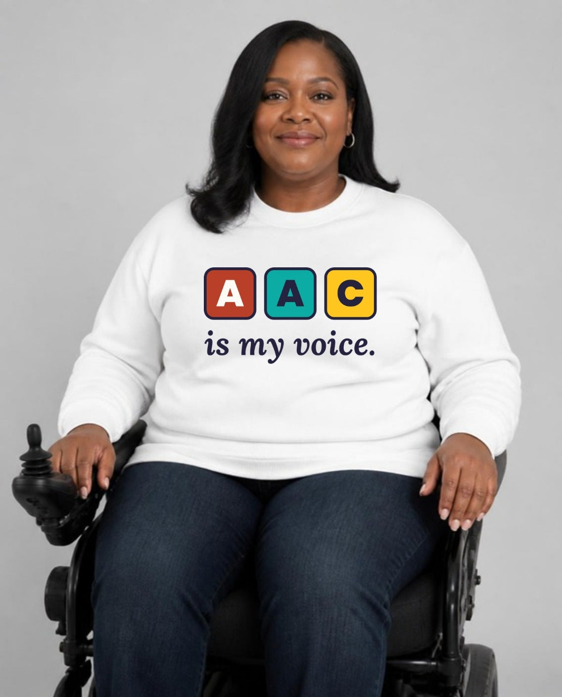 Woman who uses a power wheelchair wearing the AAC Is My Voice Adult Sweatshirt in White