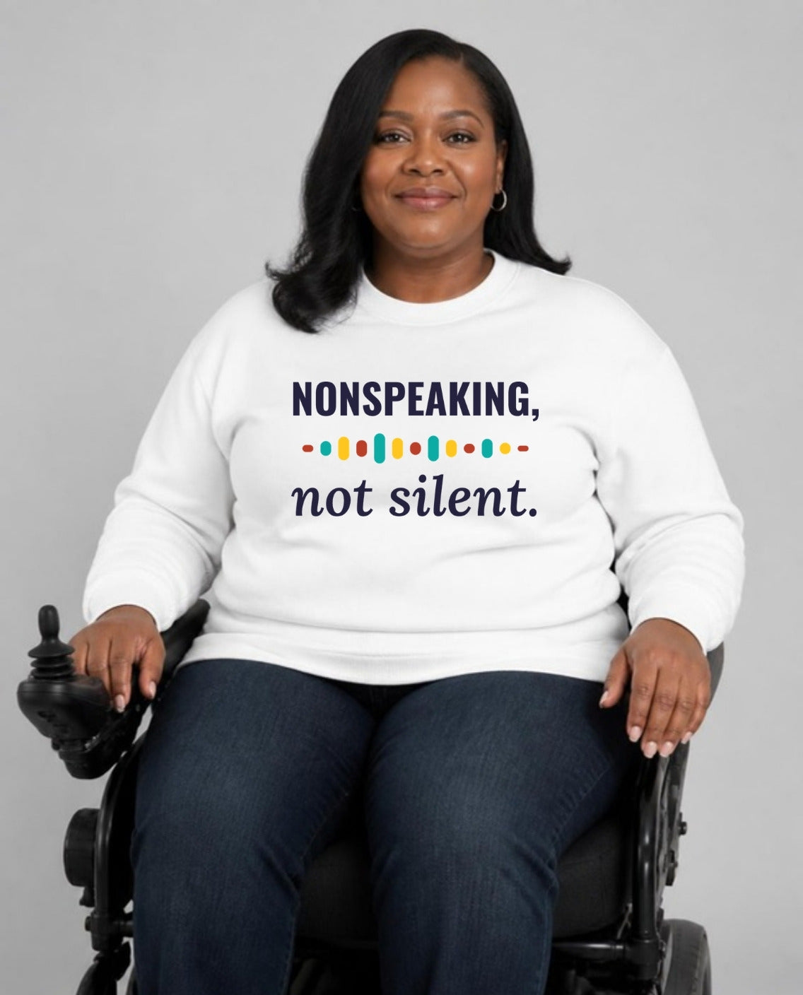 Woman who uses a power wheelchair wearing the Nonspeaking, Not Silent Adult Sweatshirt in White