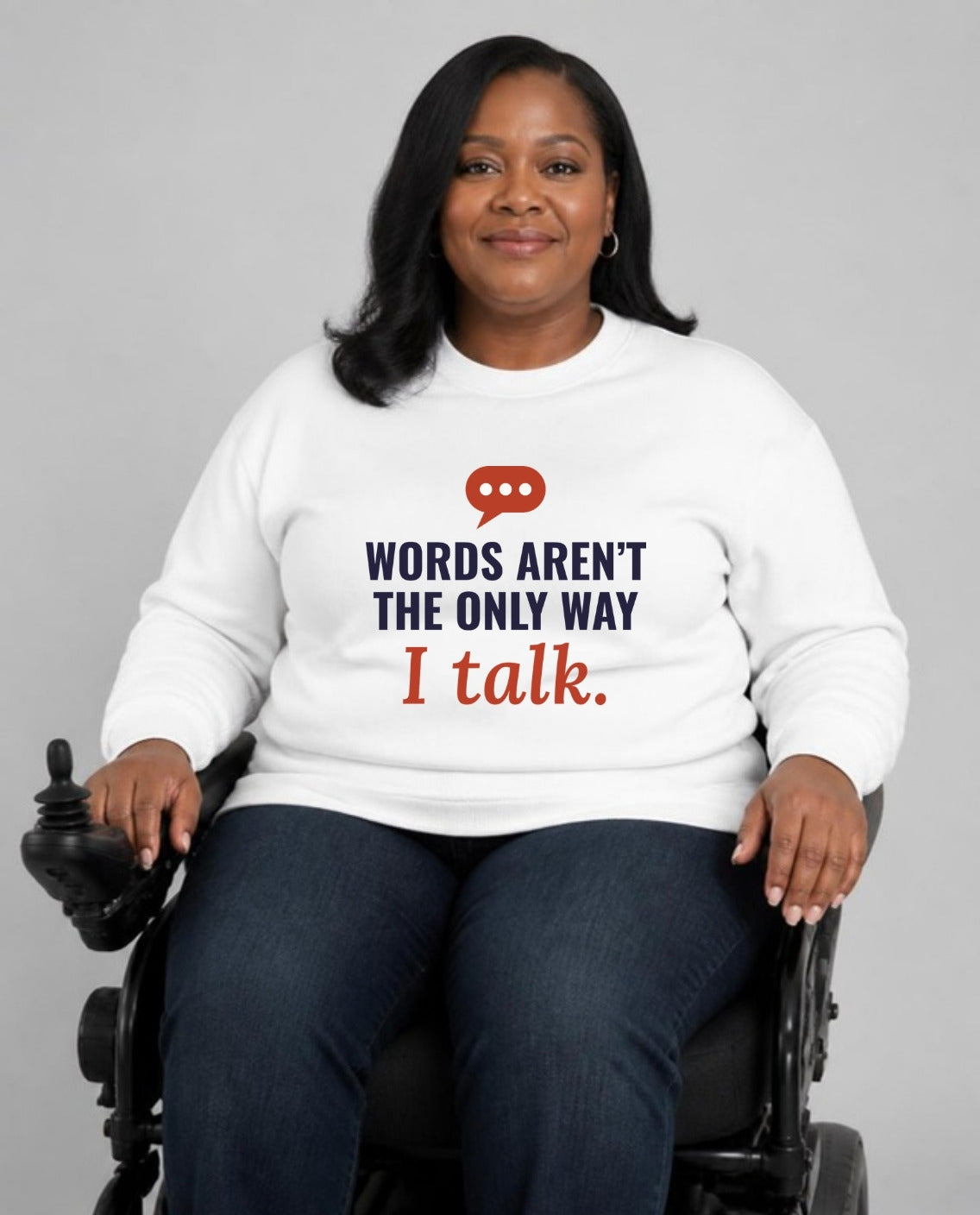 Woman who uses a power wheelchair wearing the Words Aren’t the Only Way I Talk Adult Sweatshirt in White