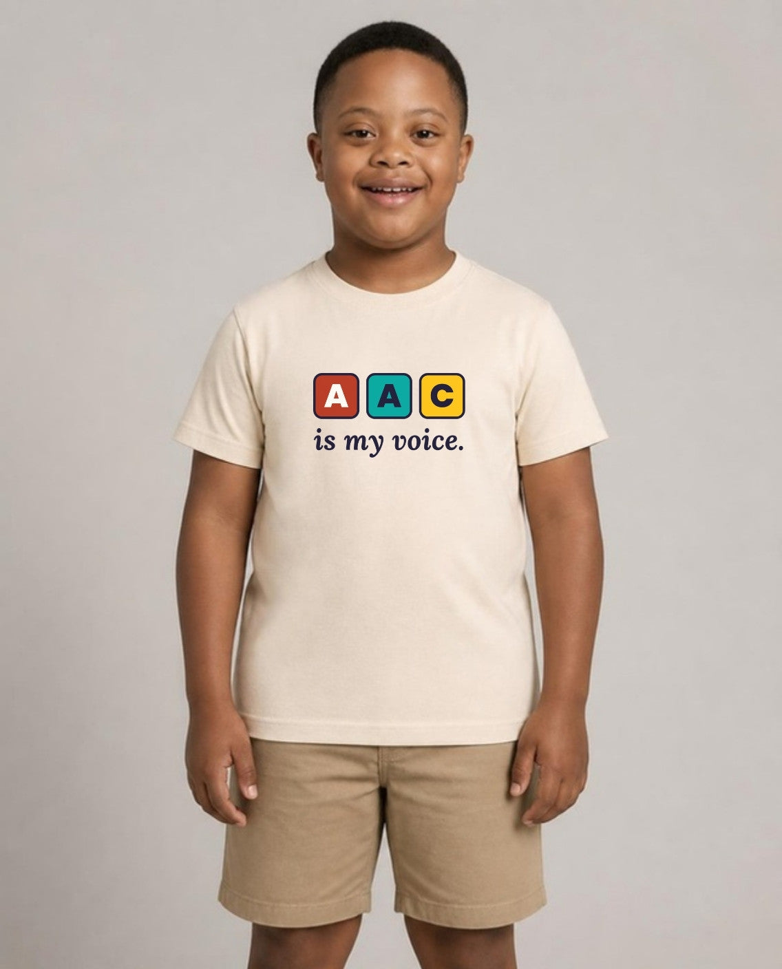 Boy with Down syndrome wearing the AAC Is My Voice Youth Tee in Natural