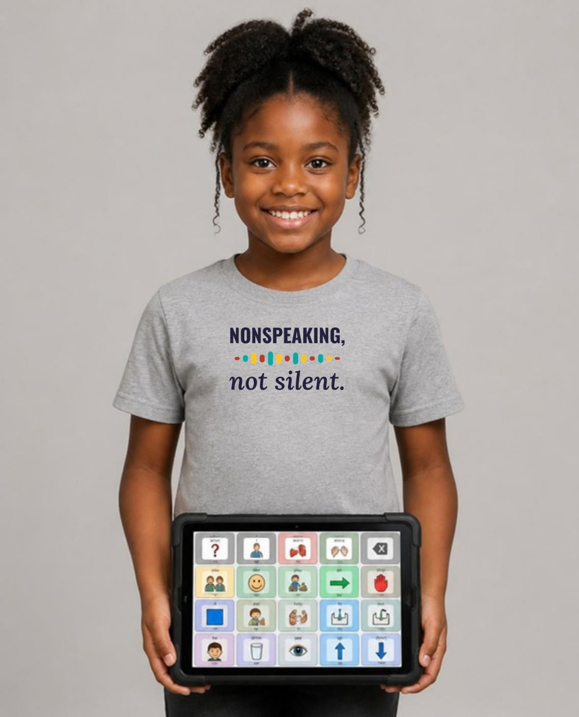 Girl holding her AAC talker wearing the Nonspeaking, Not Silent Youth Tee in Athletic Heather