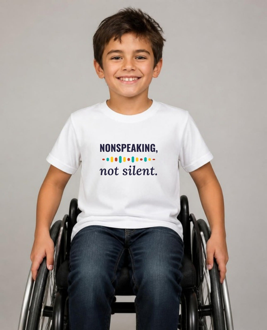 Boy who uses a wheelchair wearing the Nonspeaking, Not Silent Youth Tee in White