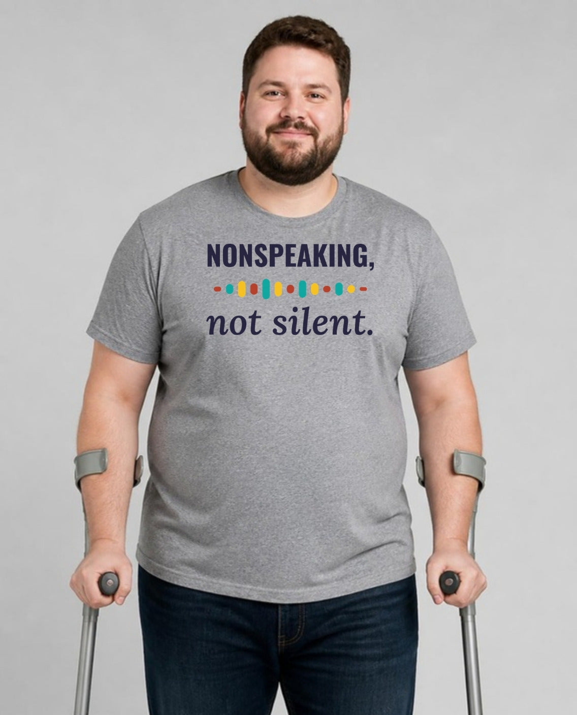 Man who uses forearm crutches wearing the Nonspeaking, Not Silent Adult Tee in Athletic Heather