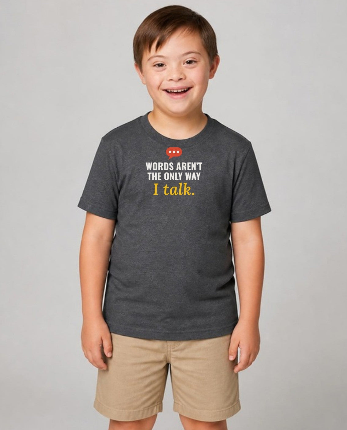 Boy with Down syndrome wearing the dark grey Words Aren’t the Only Way I Talk youth tee