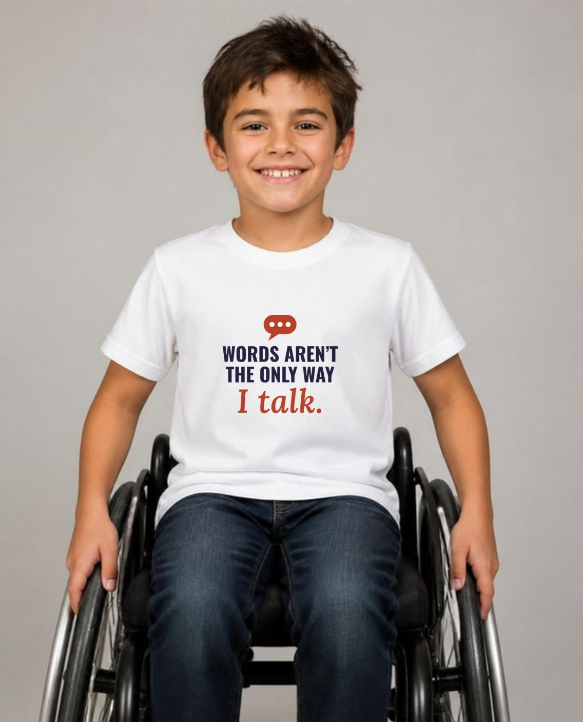 Boy who uses a wheelchair wearing the Words Aren’t the Only Way I Talk Youth Tee in White