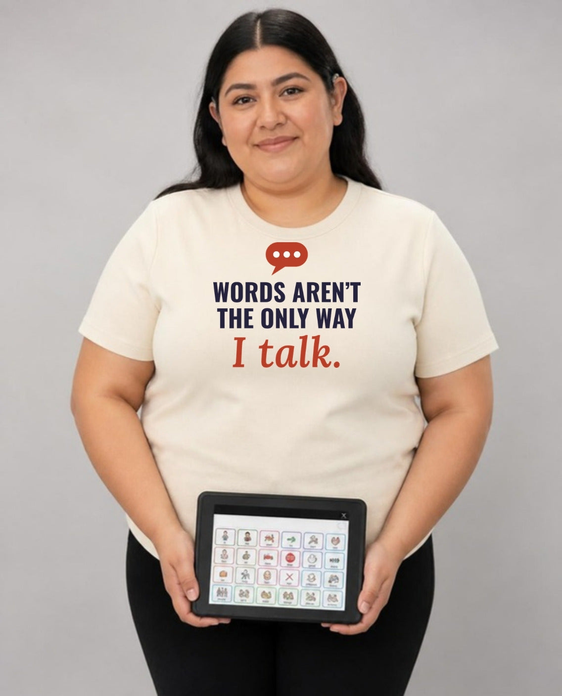 Woman holding her AAC talker, wearing the Words Aren’t the Only Way I Talk Adult Tee in Natural