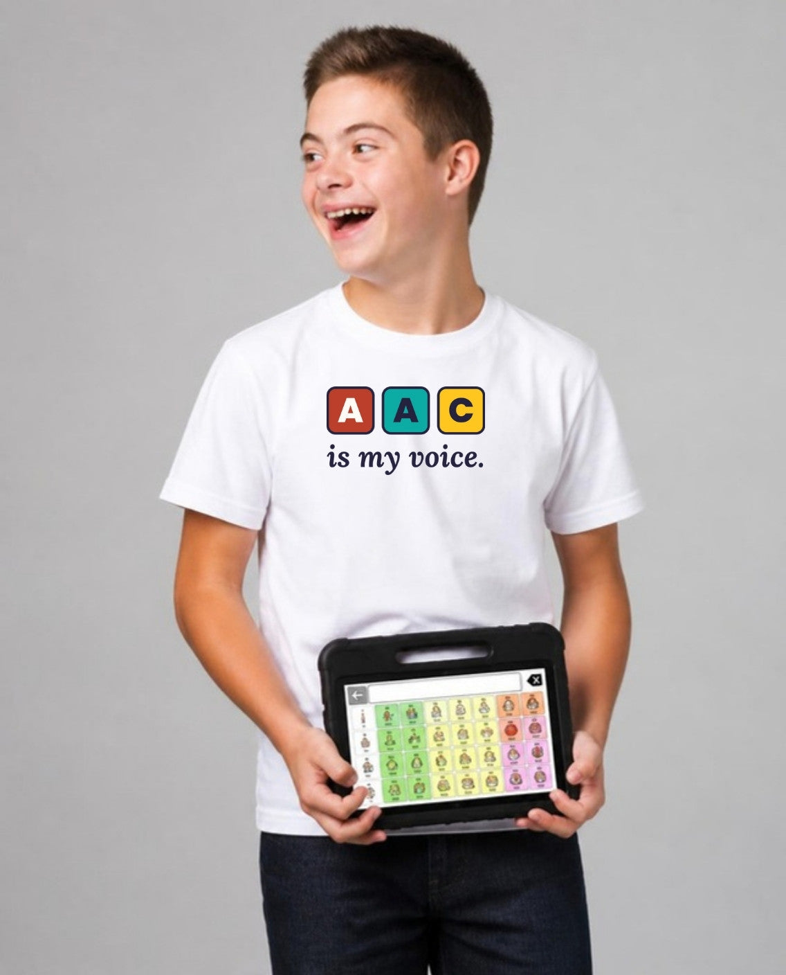 Teen holding his AAC talker, looking away, wearing the AAC Is My Voice Adult Tee in White