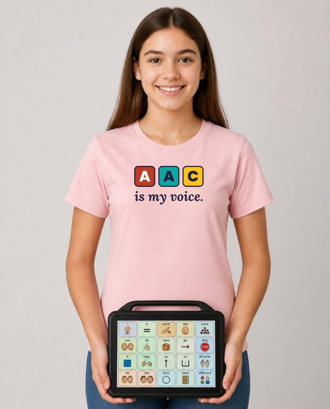 Teen holding her AAC talker wearing the AAC Is My Voice Adult Tee in Pink