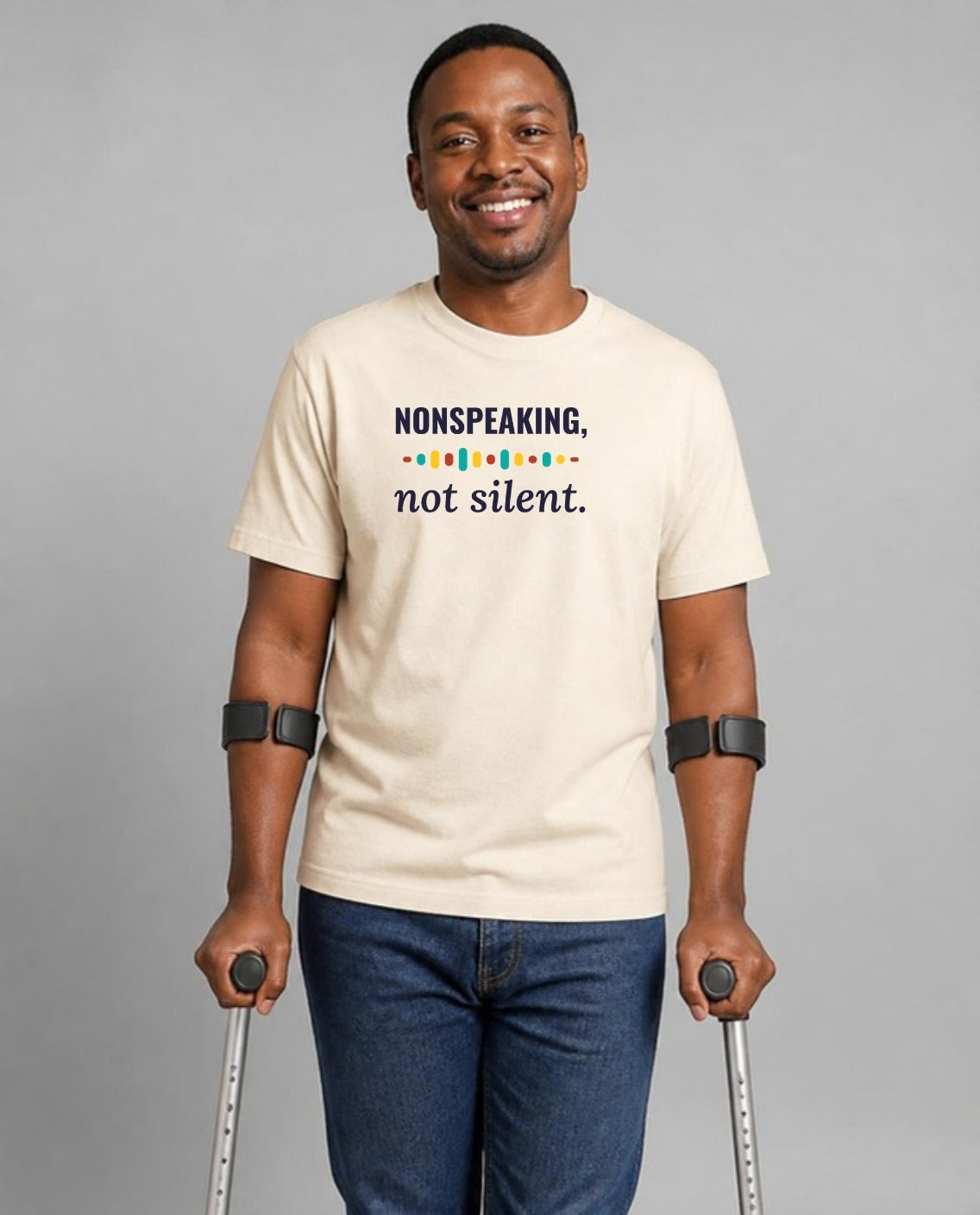 Man who uses forearm crutches wearing the Nonspeaking, Not Silent Adult Tee in Natural