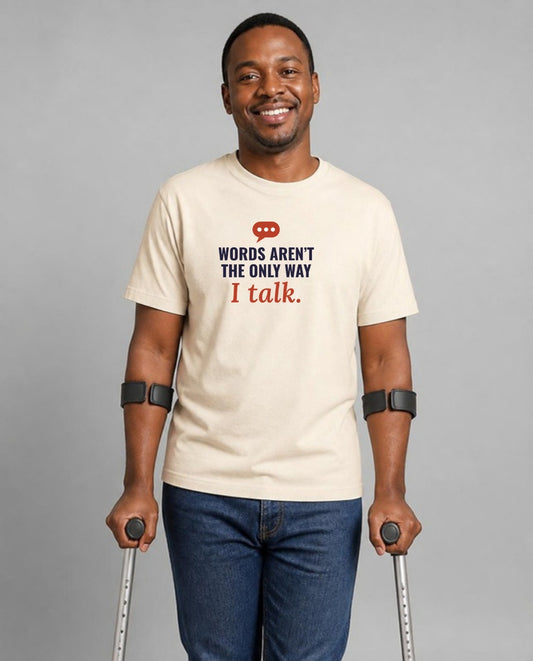 Man who uses forearm crutches wearing the Words Aren’t the Only Way I Talk Adult Tee in Natural