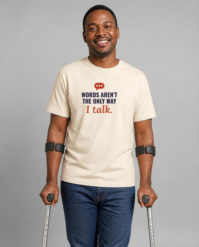 Man who uses forearm crutches wearing the Words Aren’t the Only Way I Talk Adult Tee in Natural
