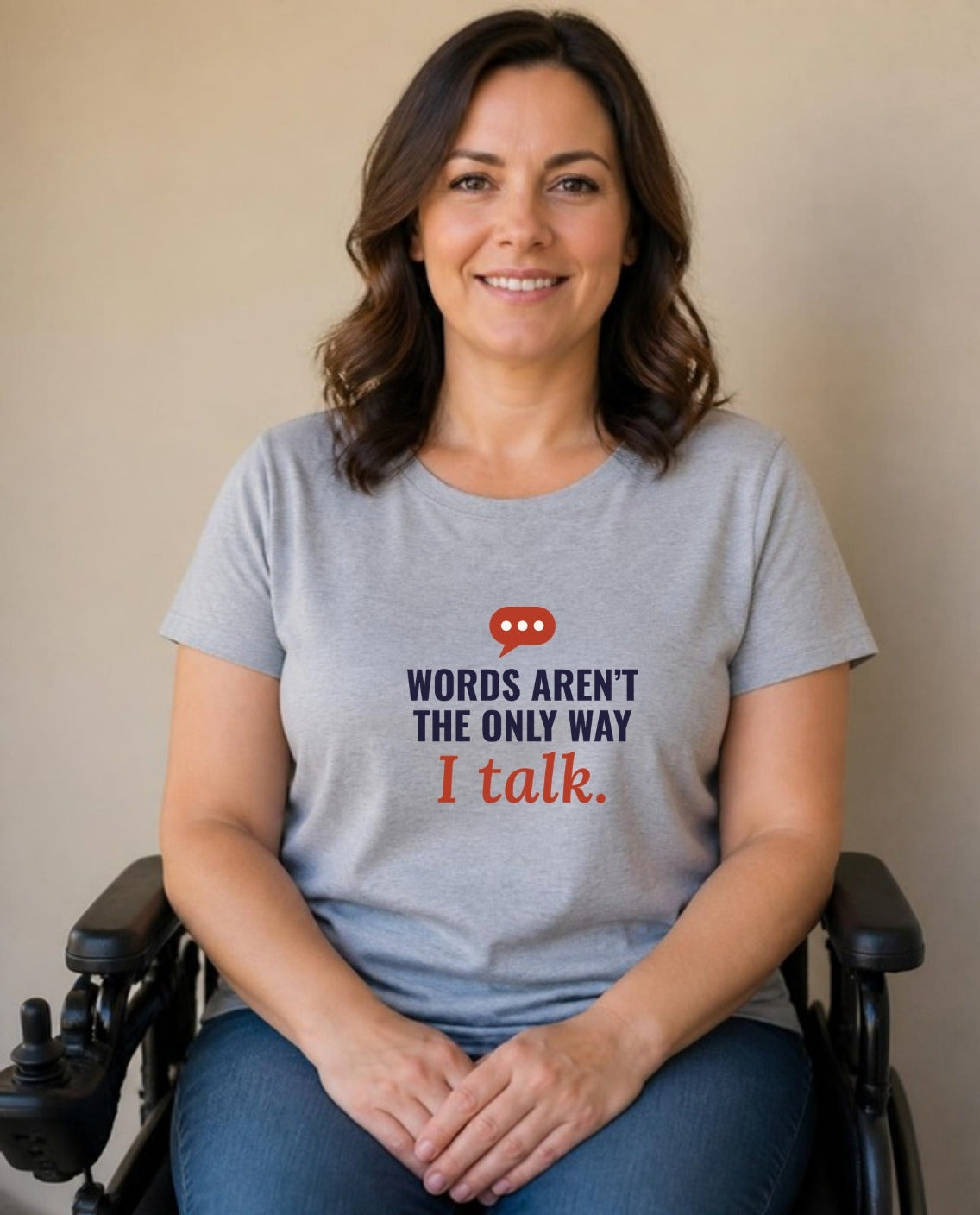 Woman who uses a power wheelchair wearing the Words Aren’t the Only Way I Talk Adult Tee in Athletic Heather