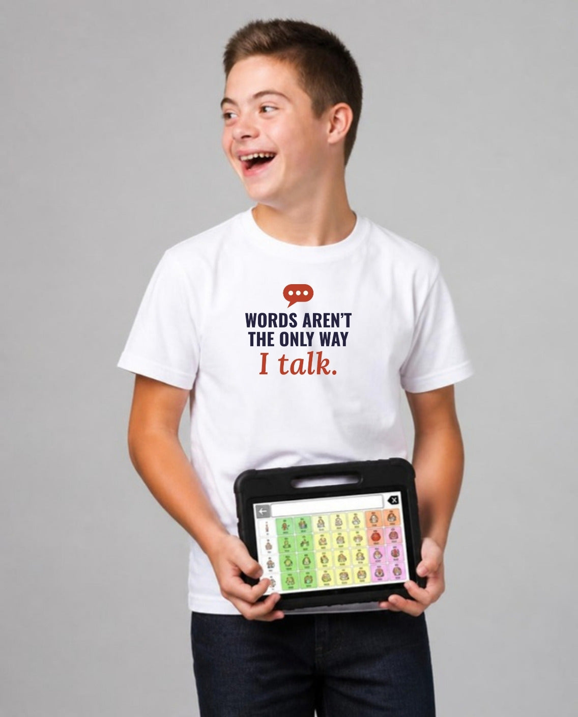 Teen holding his AAC talker, looking away, wearing the Words Aren’t the Only Way I Talk Adult Tee in White