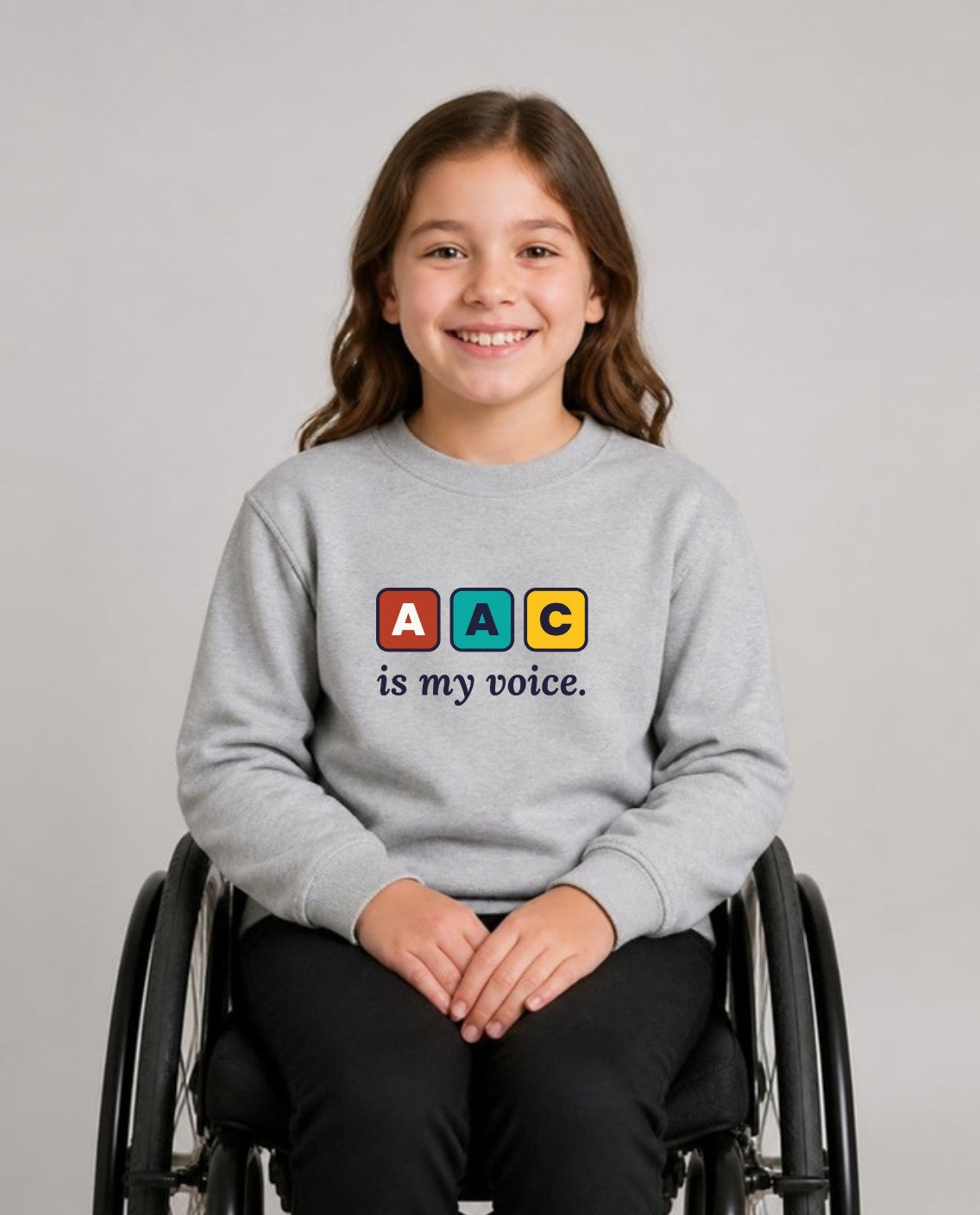 Girl who uses a wheelchair wearing the AAC Is My Voice Youth Sweatshirt in Sport Grey