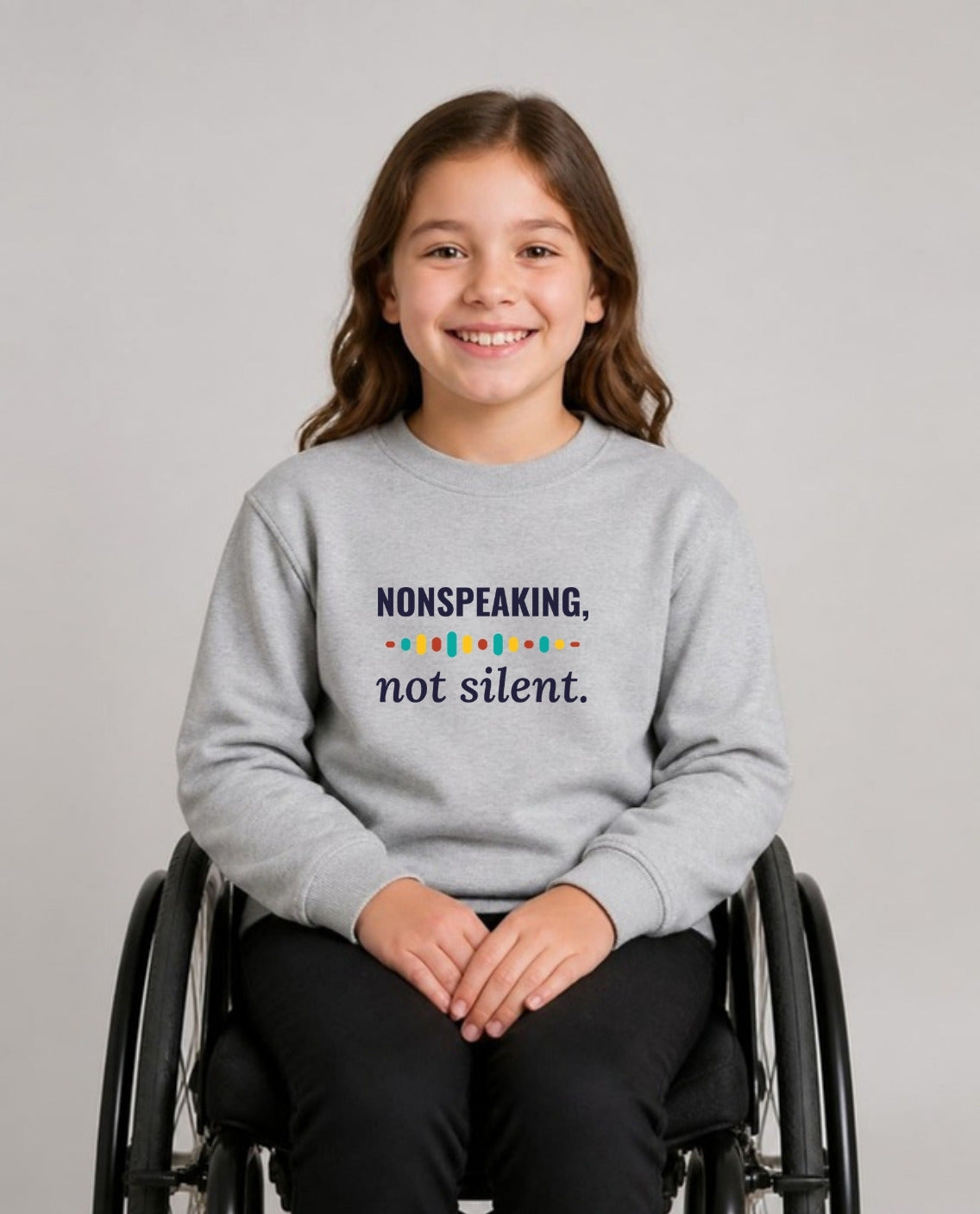 Girl who uses a wheelchair wearing the Nonspeaking, Not Silent Youth Sweatshirt in Sport Grey