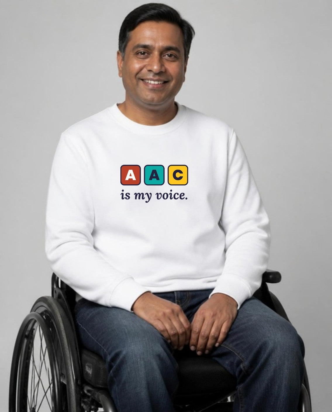 Man who uses a wheelchair wearing the AAC Is My Voice Adult Sweatshirt in White