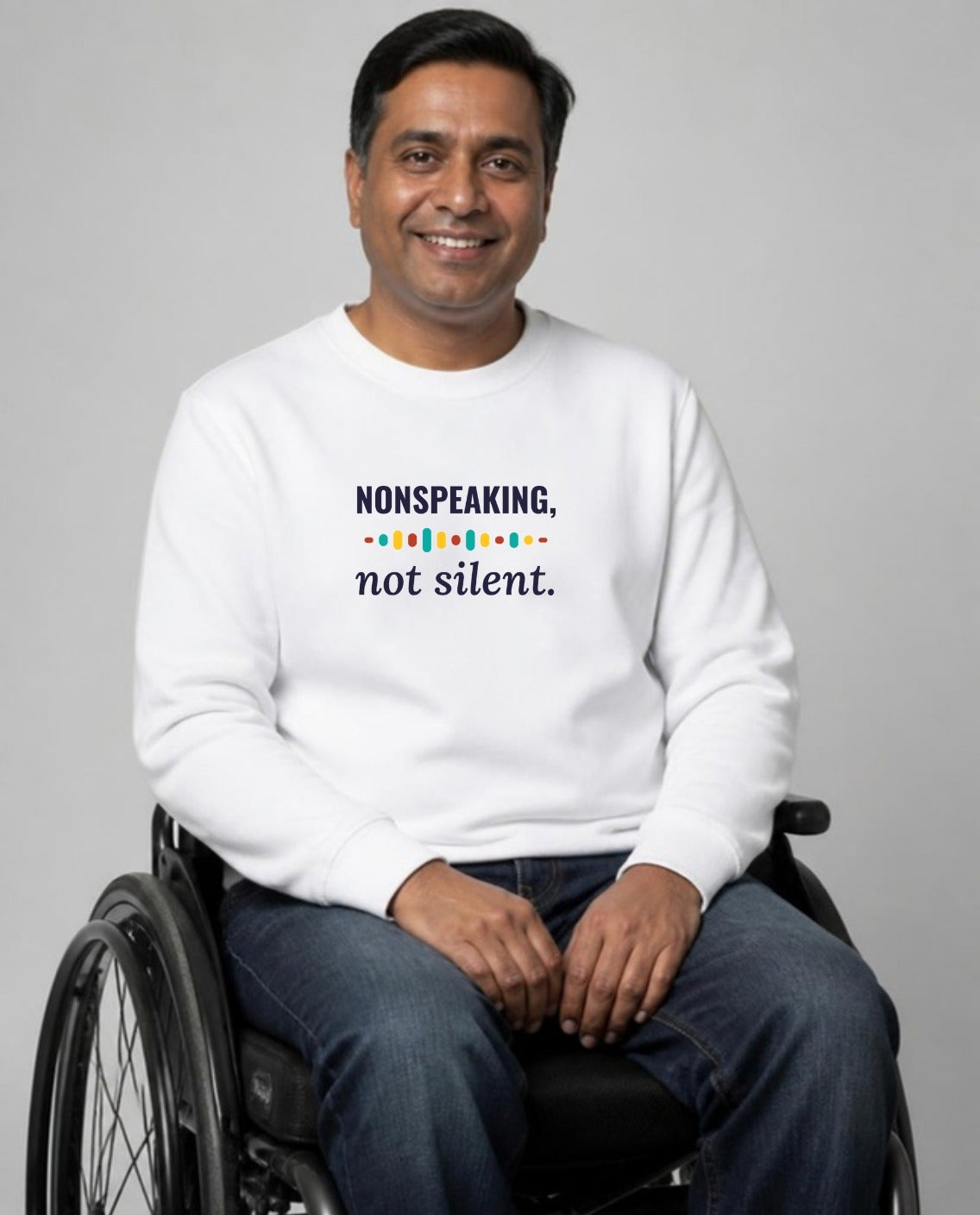 Man who uses a wheelchair wearing the Nonspeaking, Not Silent Adult Sweatshirt in White