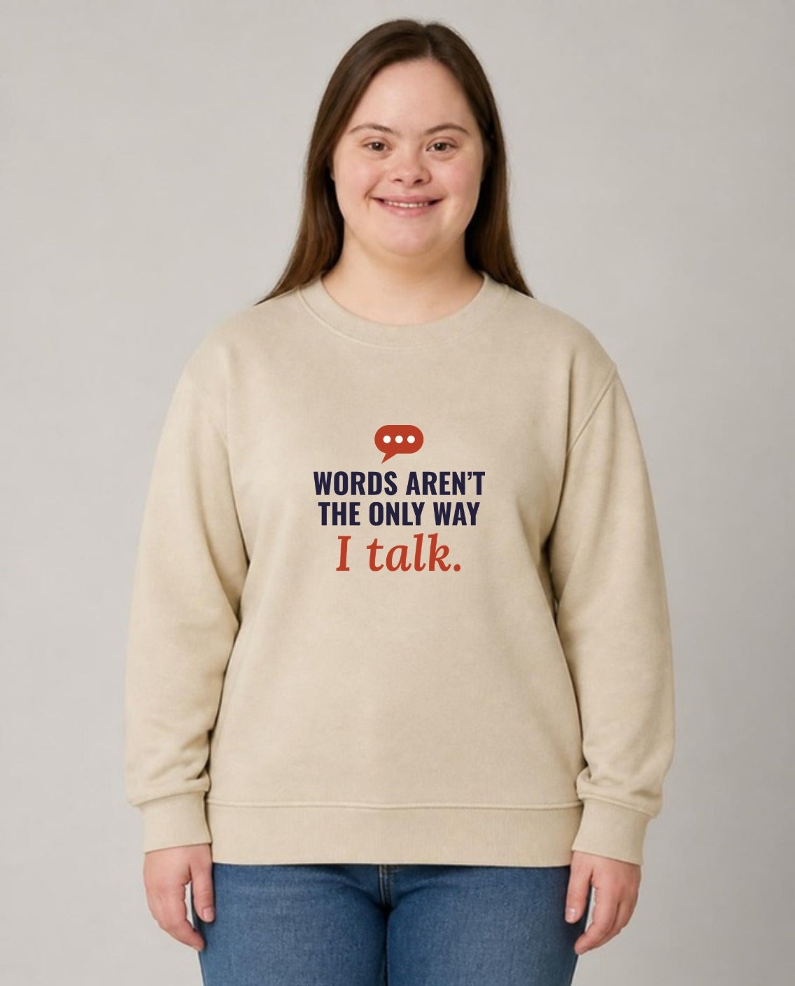 Woman with Down syndrome wearing the Words Aren’t the Only Way I Talk Adult Sweatshirt in Sand