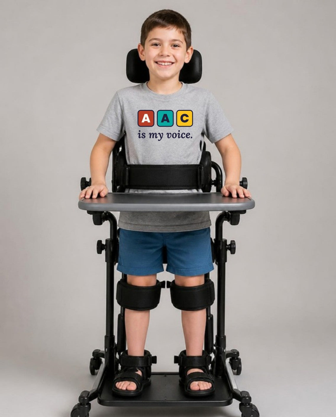 Boy standing in his stander wearing the AAC Is My Voice Youth Tee in Athletic Heather