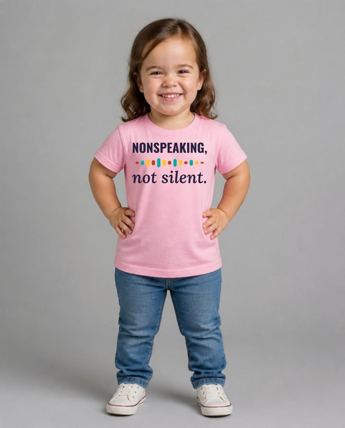 Girl with achondroplasia wearing the Nonspeaking, Not Silent Youth Tee in Pink