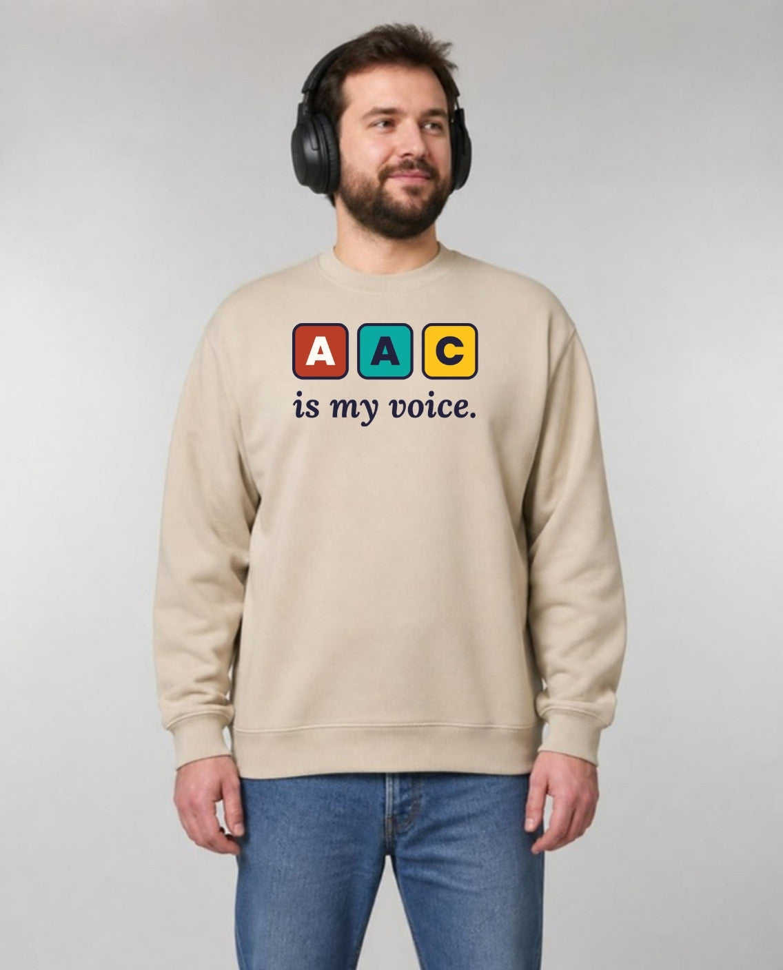 Autistic man in noise-blocking headphones wearing the AAC Is My Voice Adult Sweatshirt in Sand