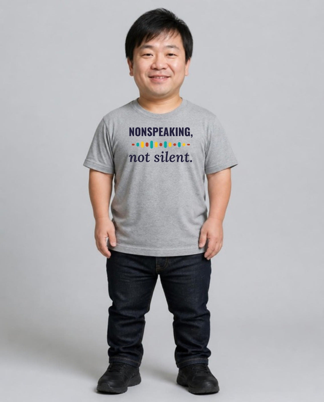 Man with achondroplasia wearing the Nonspeaking, Not Silent Adult Tee in Athletic Heather