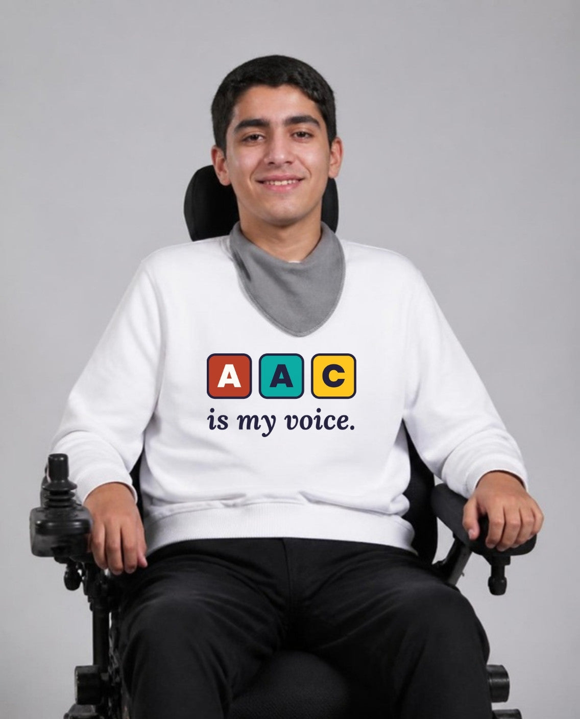 Man who uses a power wheelchair wearing the AAC Is My Voice Adult Sweatshirt in White