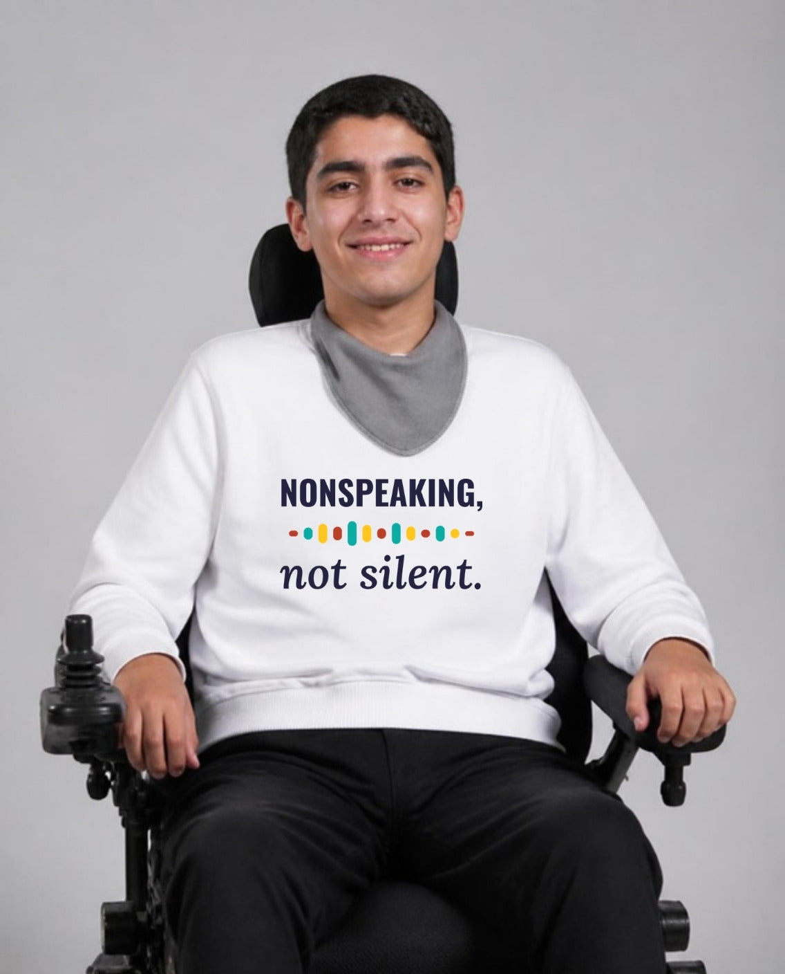 Man who uses a power wheelchair wearing the Nonspeaking, Not Silent Adult Sweatshirt in White