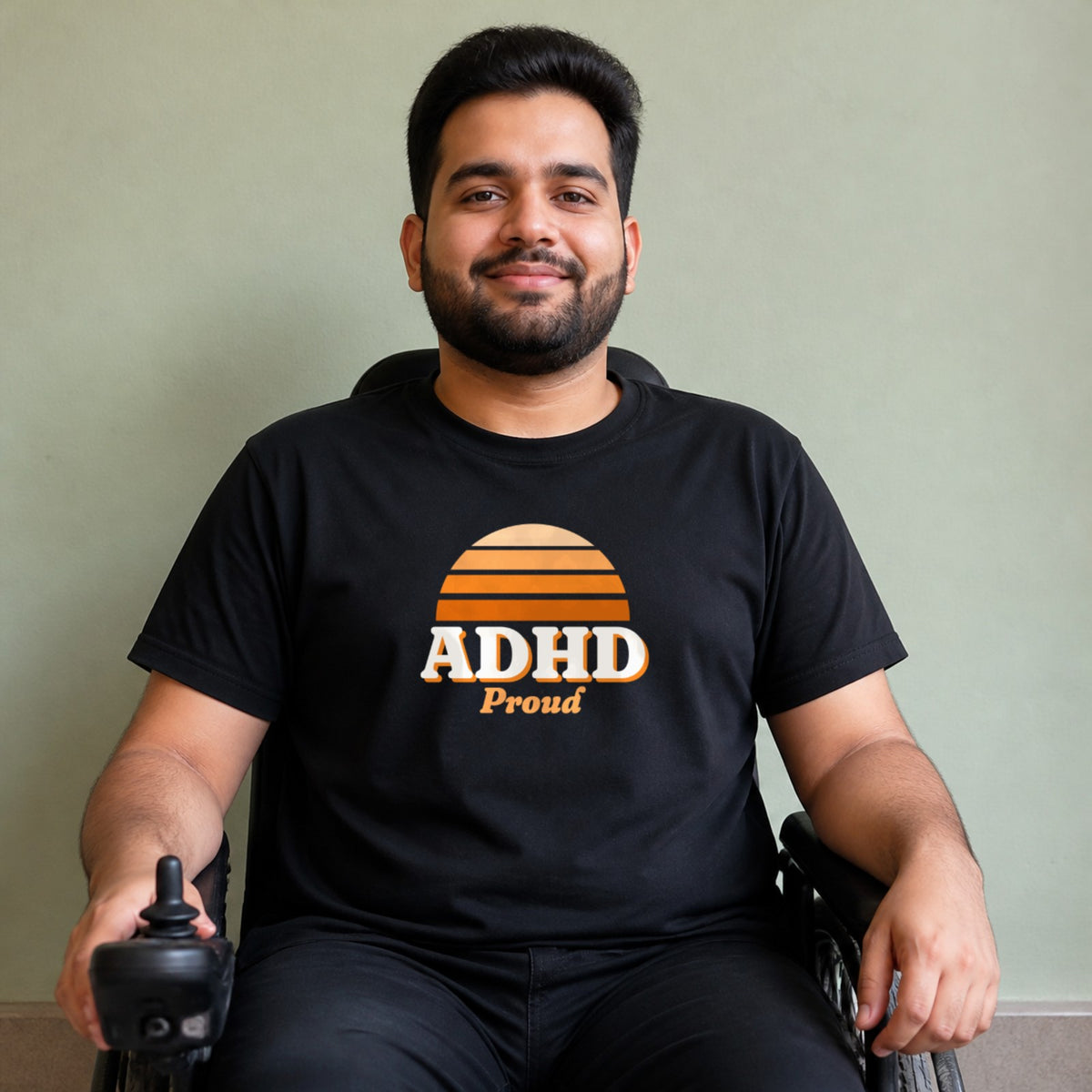 A man seated in a power wheelchair wears a black ADHD Proud tee.