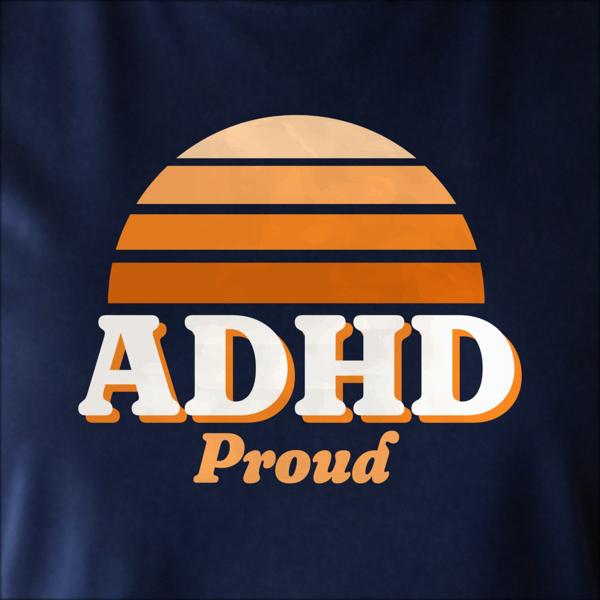 Close-up of the print on navy: a striped half-sun in orange above cream ADHD lettering with “Proud” in script.