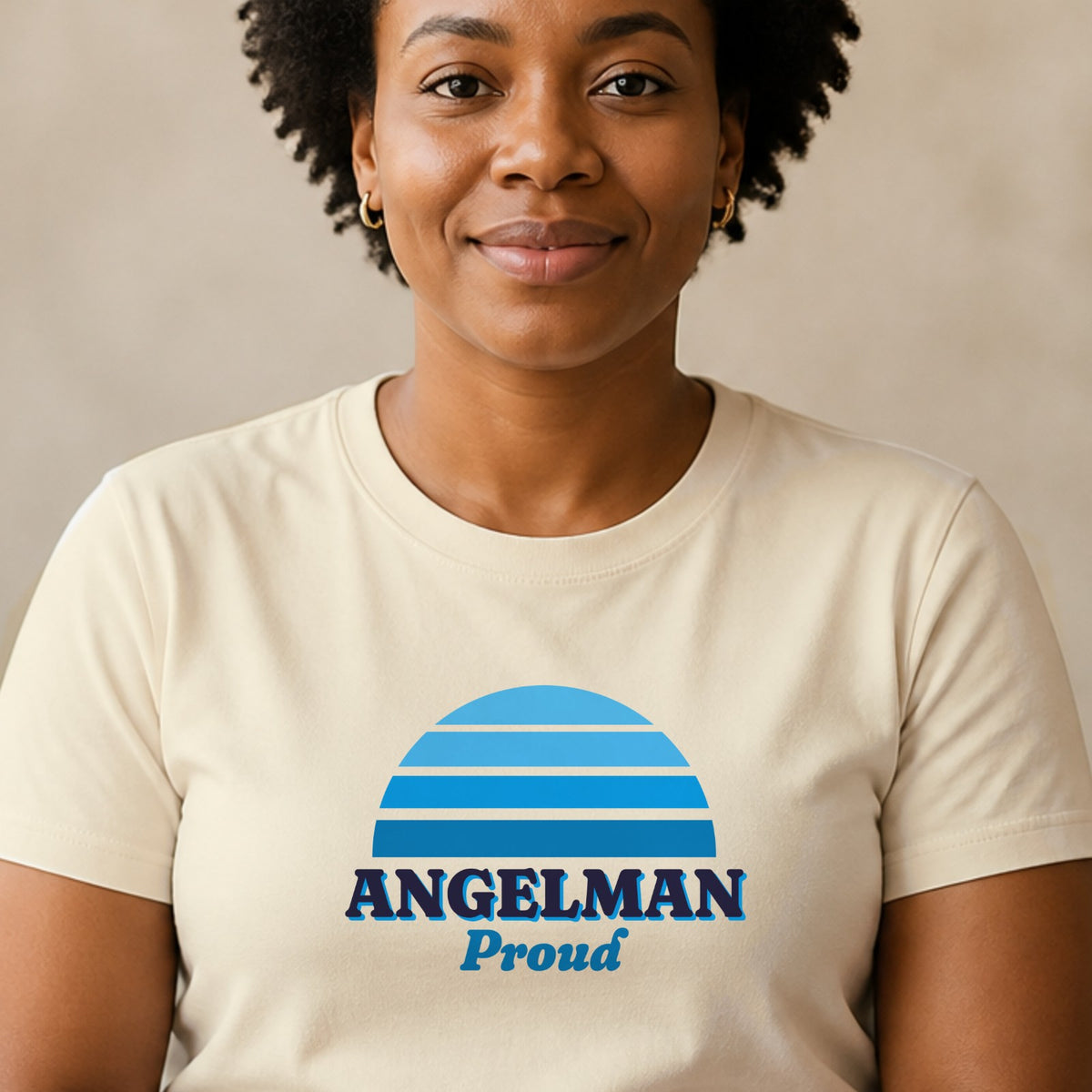 A woman wears a natural-colored Angelman Proud tee with a blue striped retro sun.