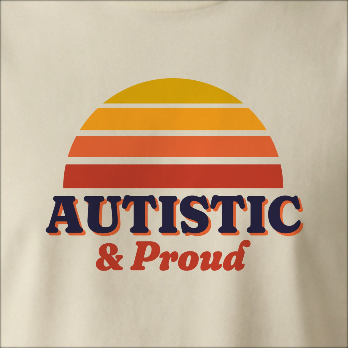 Close-up of the print on a natural tee: a striped half-sun in gold and red above bold AUTISTIC lettering with “& Proud” in script.