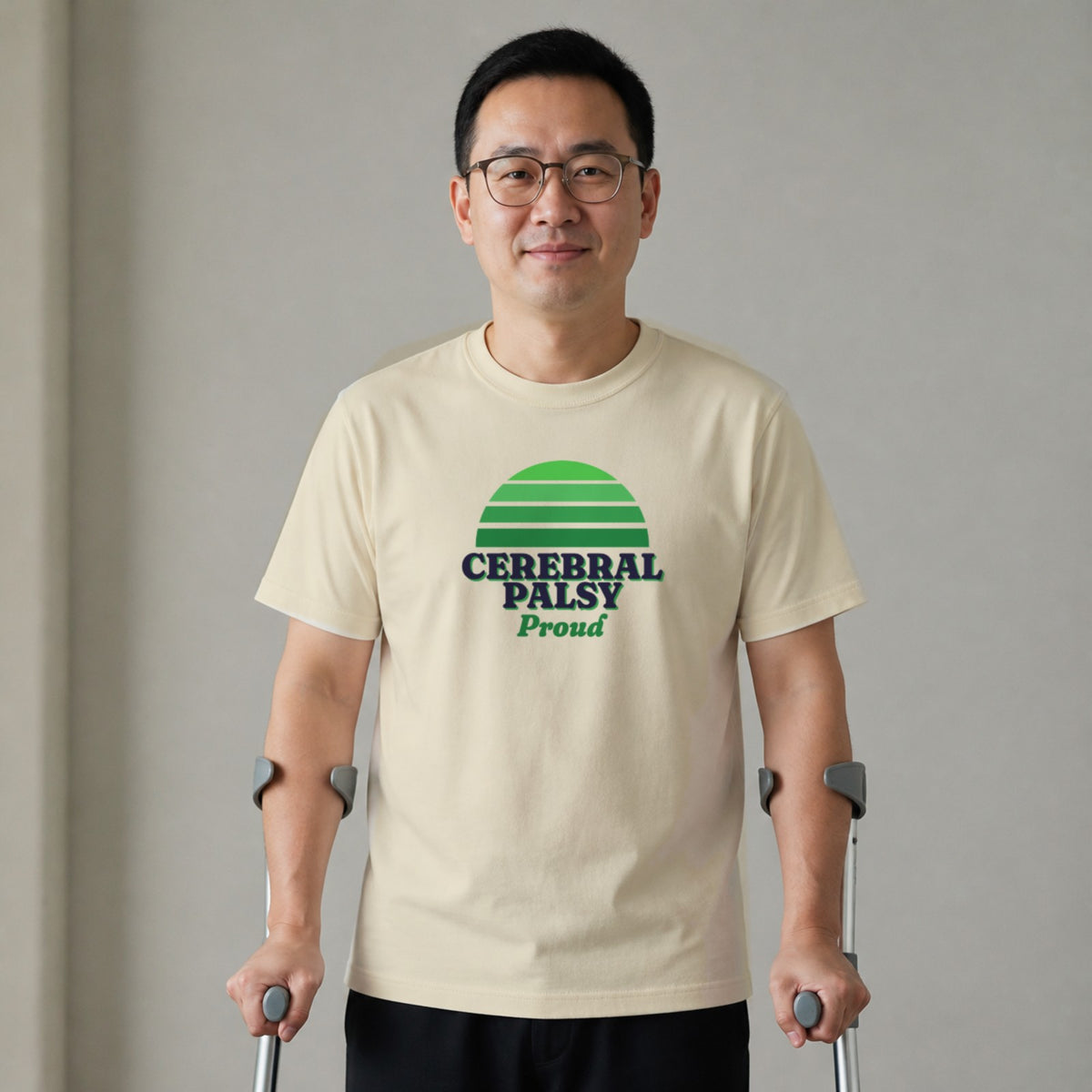 A man standing with two forearm crutches wears a natural-colored Cerebral Palsy Proud tee.