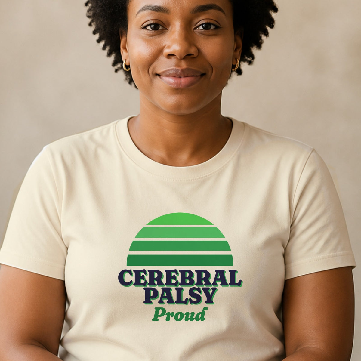 A woman wears a natural-colored Cerebral Palsy Proud tee with a green striped retro sun.