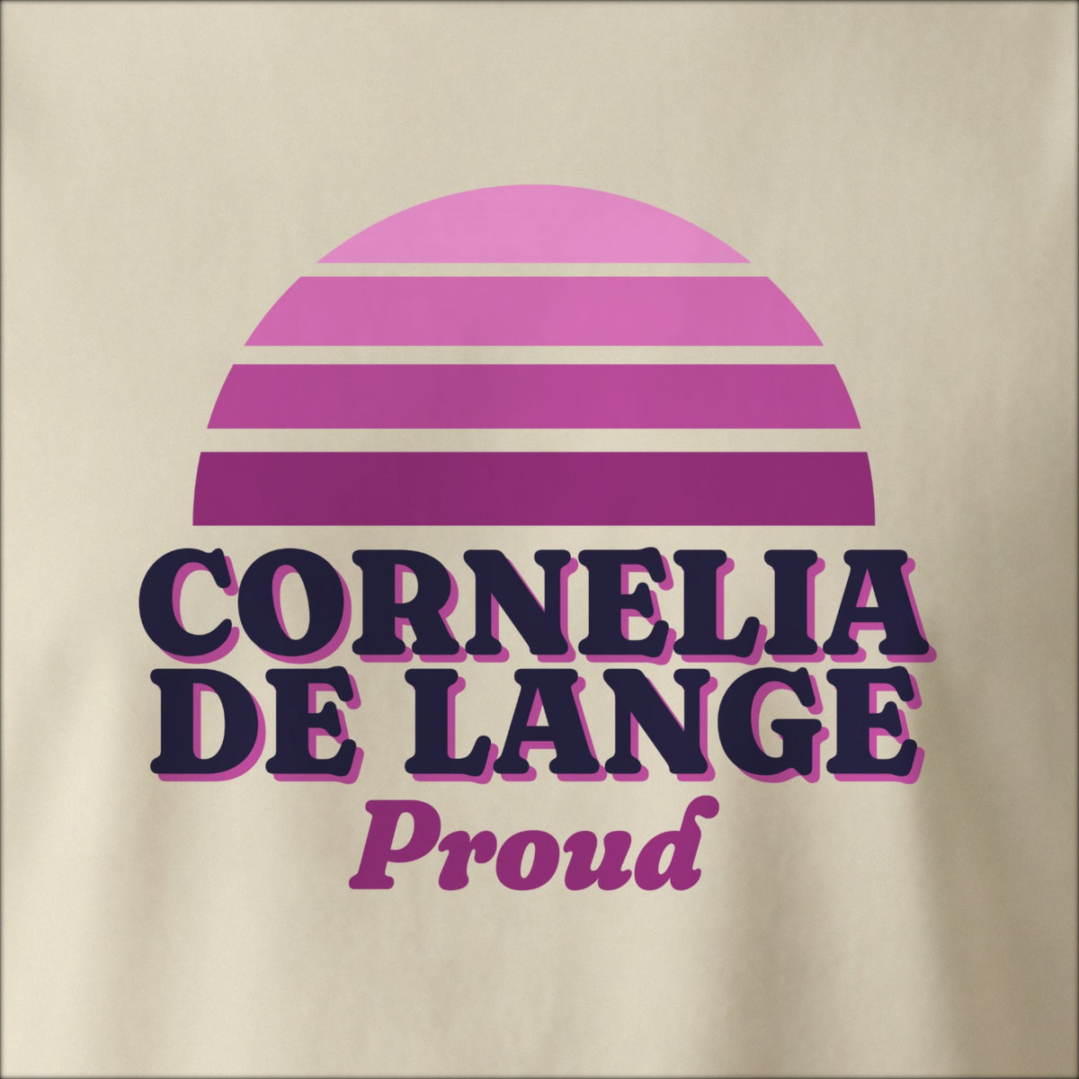 Close-up of the print on a natural tee: a striped half-sun in purple above bold CORNELIA DE LANGE lettering with “Proud” in script.