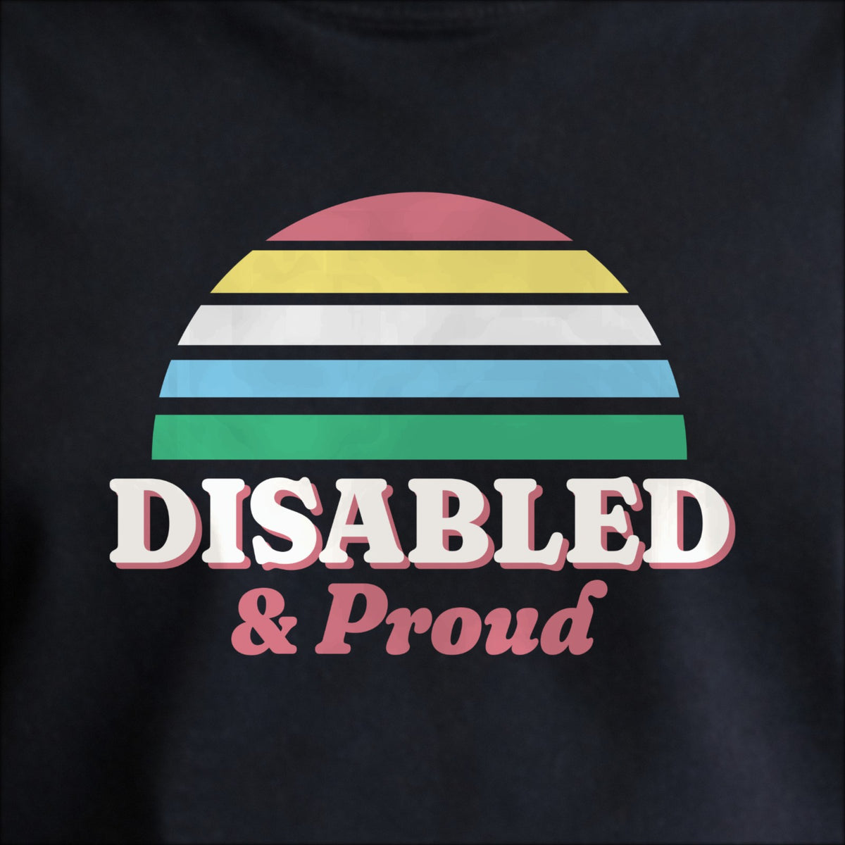 Close-up of the print on black: a five-stripe half-sun in the Disability Pride Flag colors (red, gold, white, blue and green) above cream DISABLED lettering with “& Proud” in script.