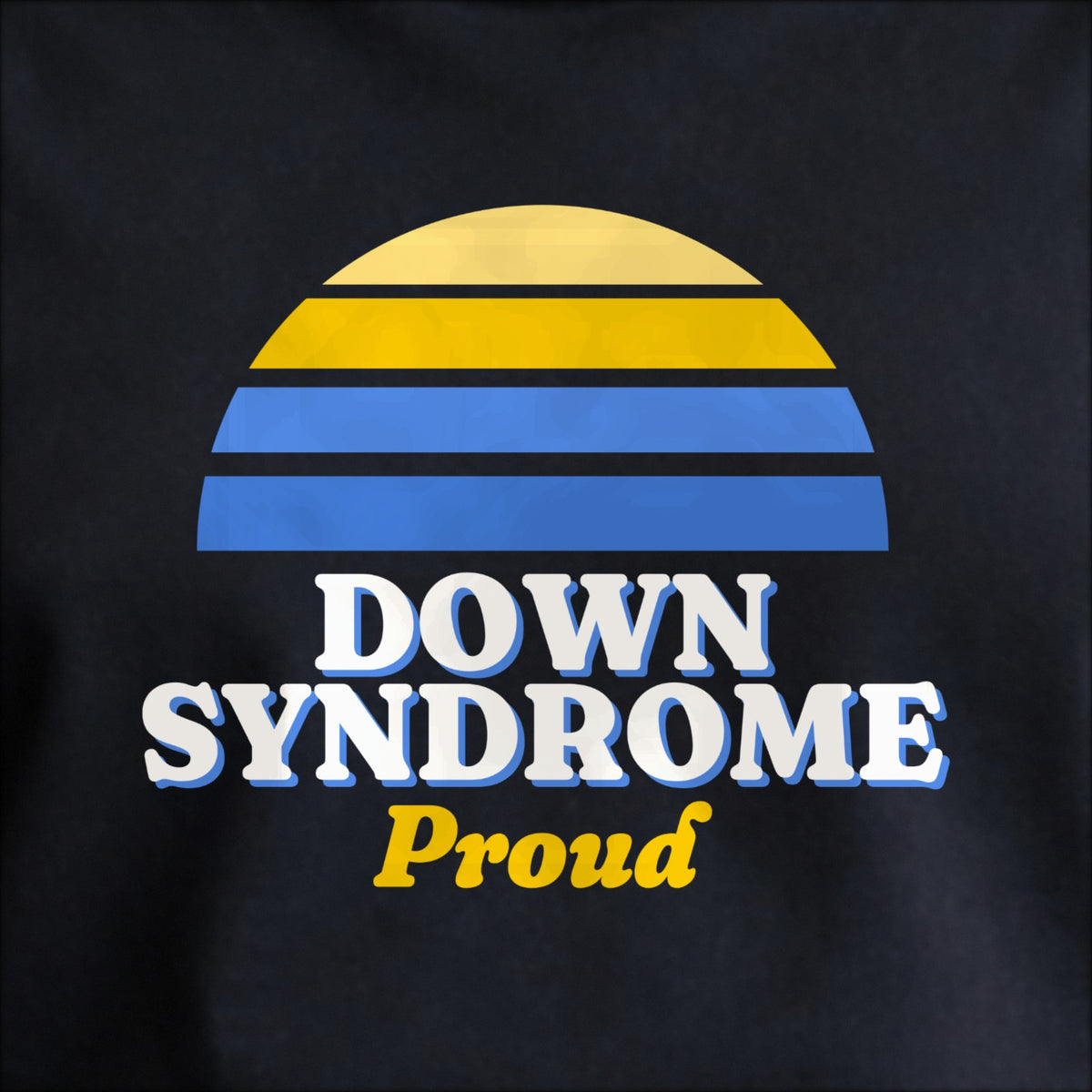 Close-up of the print on black: a striped half-sun in blue and yellow above cream DOWN SYNDROME lettering with “Proud” in script.