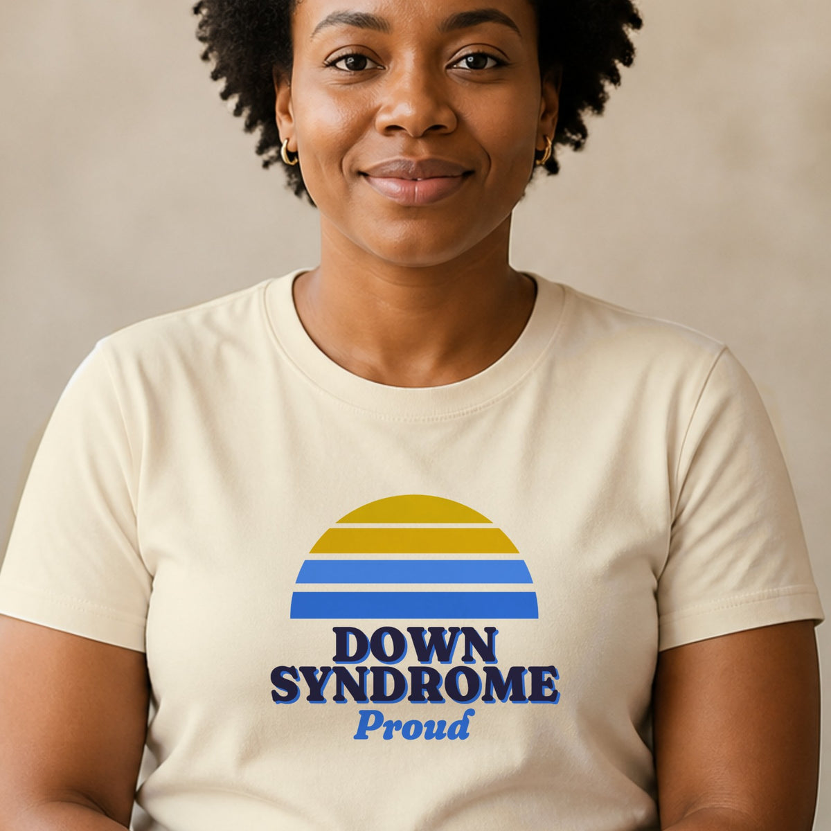 A woman wears a natural-colored Down syndrome Proud tee with a blue and yellow striped retro sun.