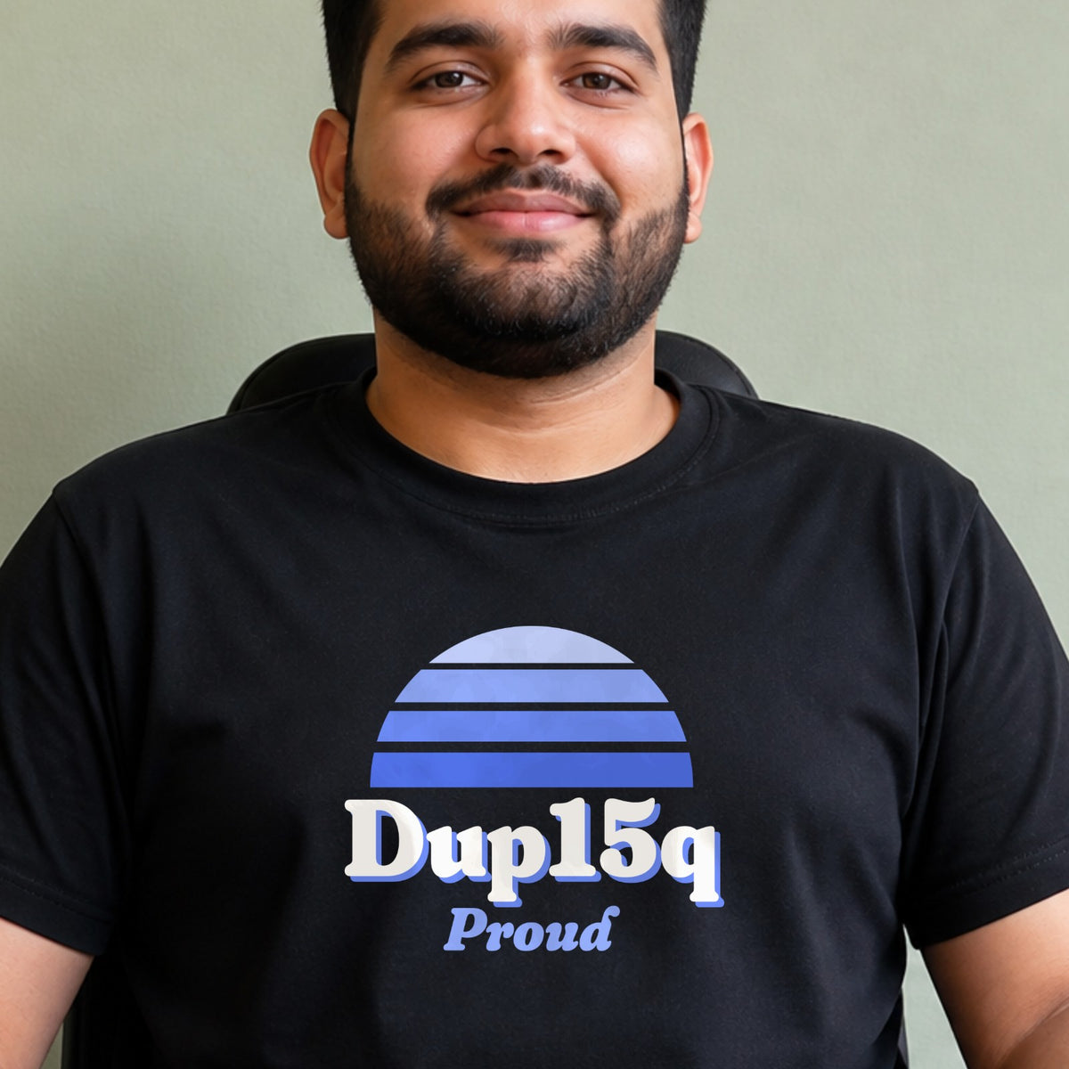 A man wears a black Dup15q Proud tee with a blue striped retro sun.