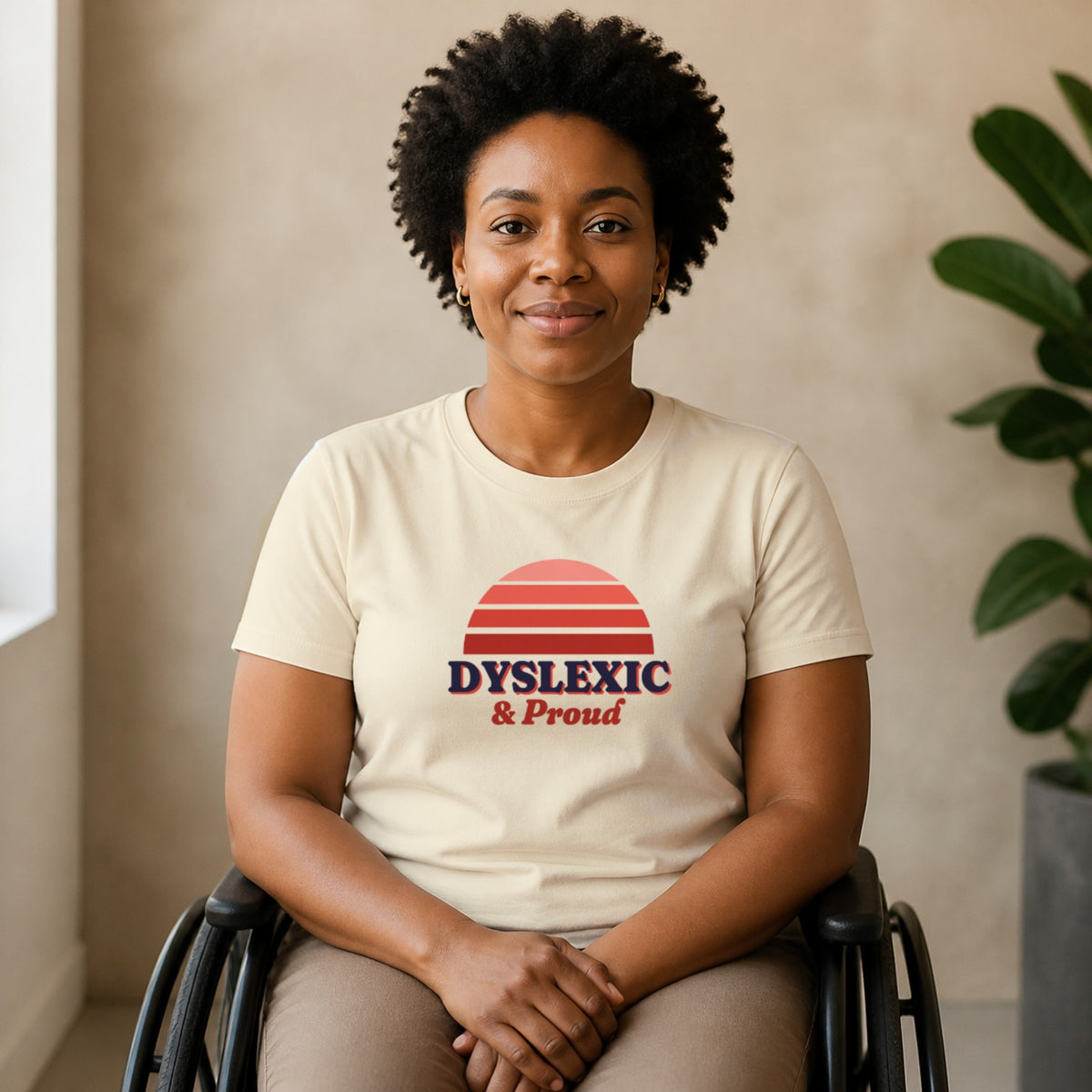 A woman seated in a wheelchair wears a natural-colored Dyslexic & Proud tee.