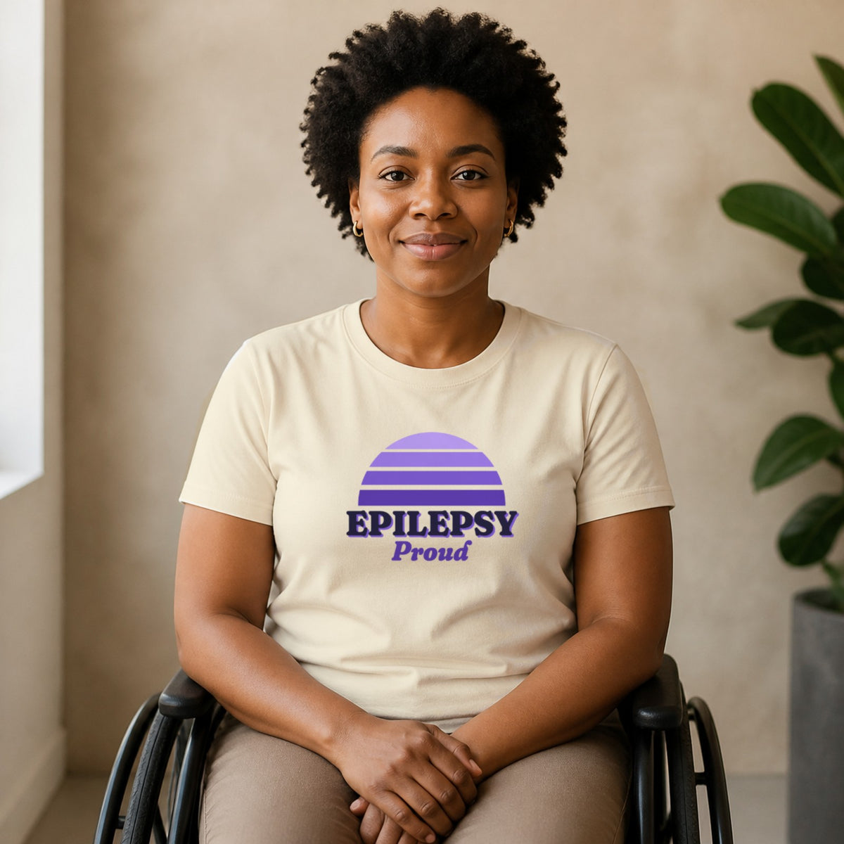 A woman seated in a wheelchair wears a natural-colored Epilepsy Proud tee.