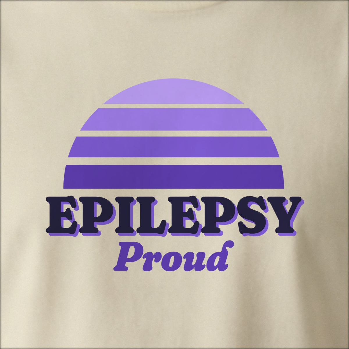 Close-up of the print on a natural tee: a striped half-sun in purple above bold EPILEPSY lettering with “Proud” in script.