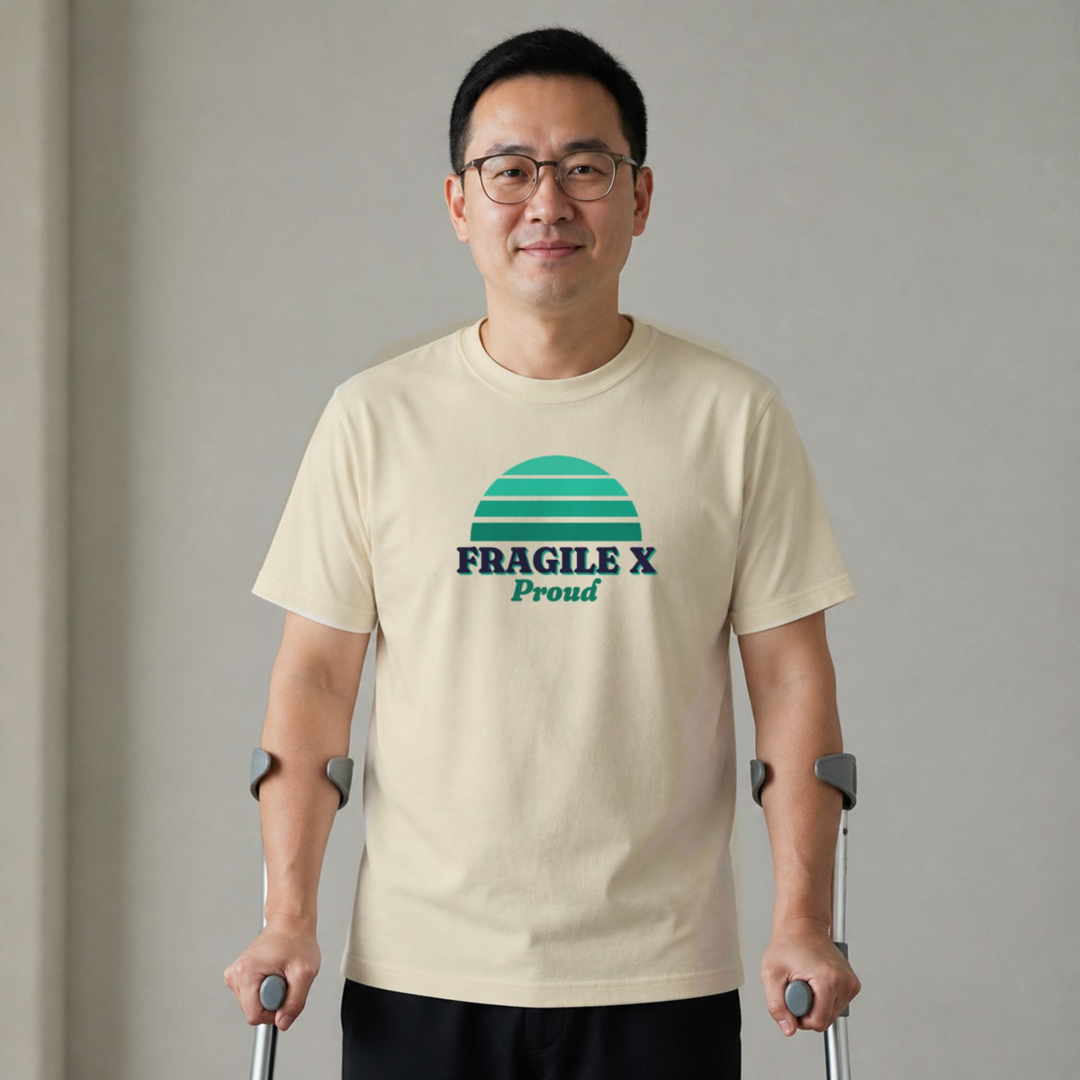 A man standing with two forearm crutches wears a natural-colored Fragile X Proud tee.
