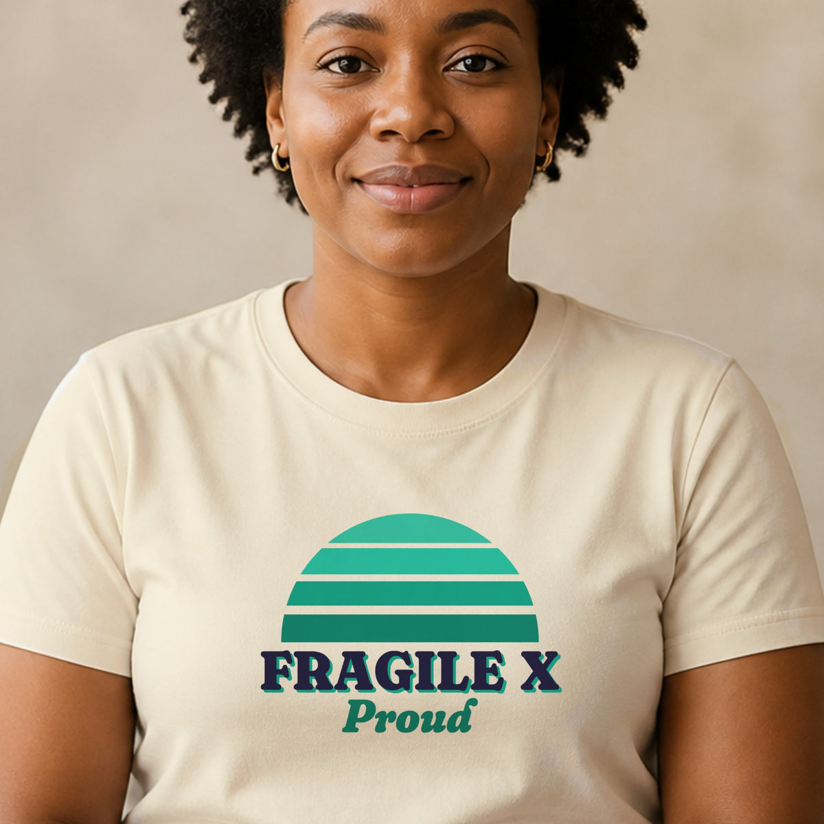 A woman wears a natural-colored Fragile X Proud tee with a teal striped retro sun.