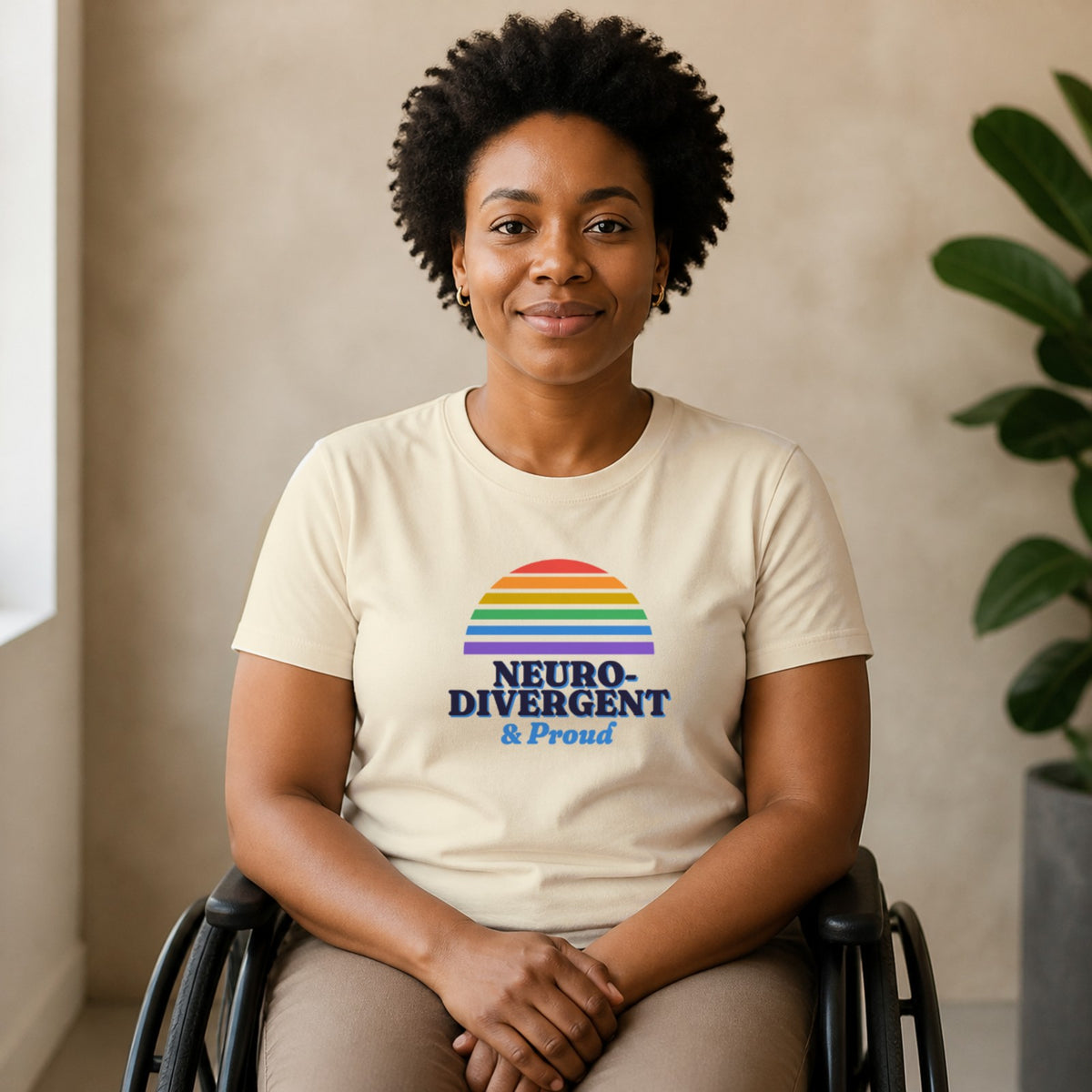 A woman seated in a wheelchair wears a natural-colored Neurodivergent & Proud tee.