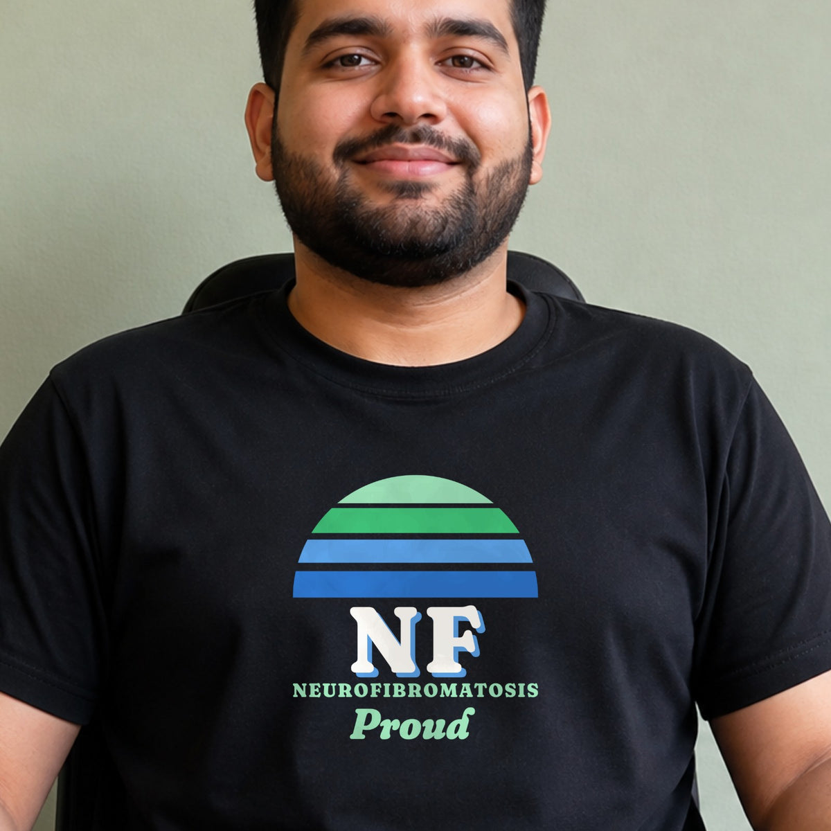 A man wears a black NF Proud tee with a green and blue striped retro sun.