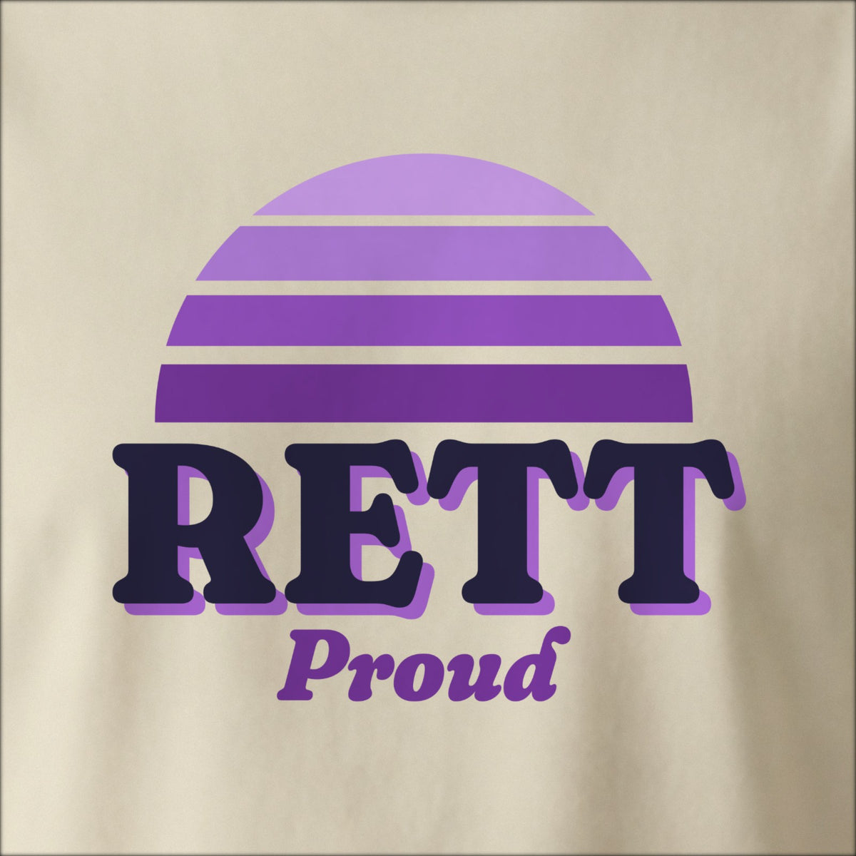 Close-up of the print on a natural tee: a striped half-sun in purple above bold RETT lettering with “Proud” in script.