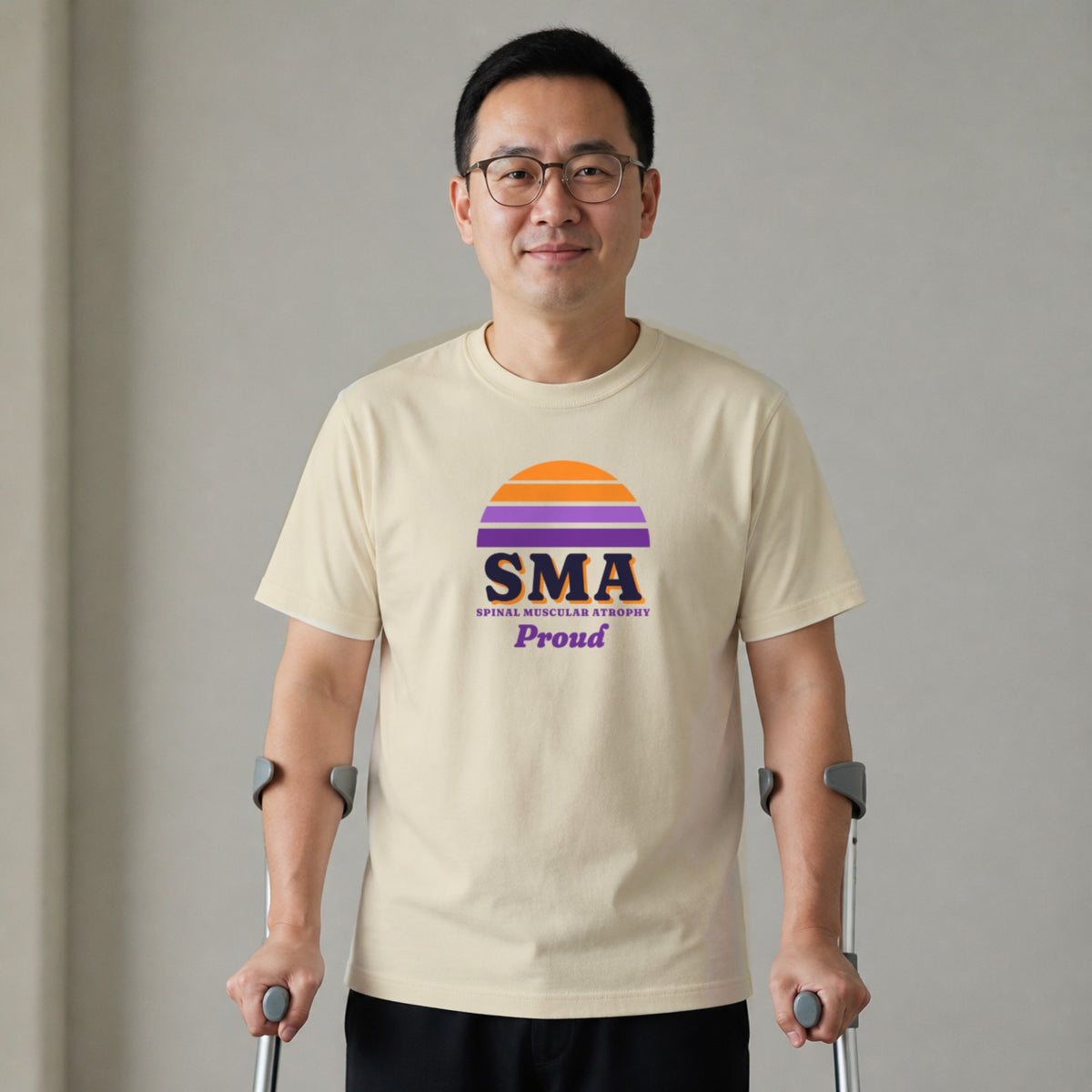 A man standing with two forearm crutches wears a natural-colored SMA Proud tee.